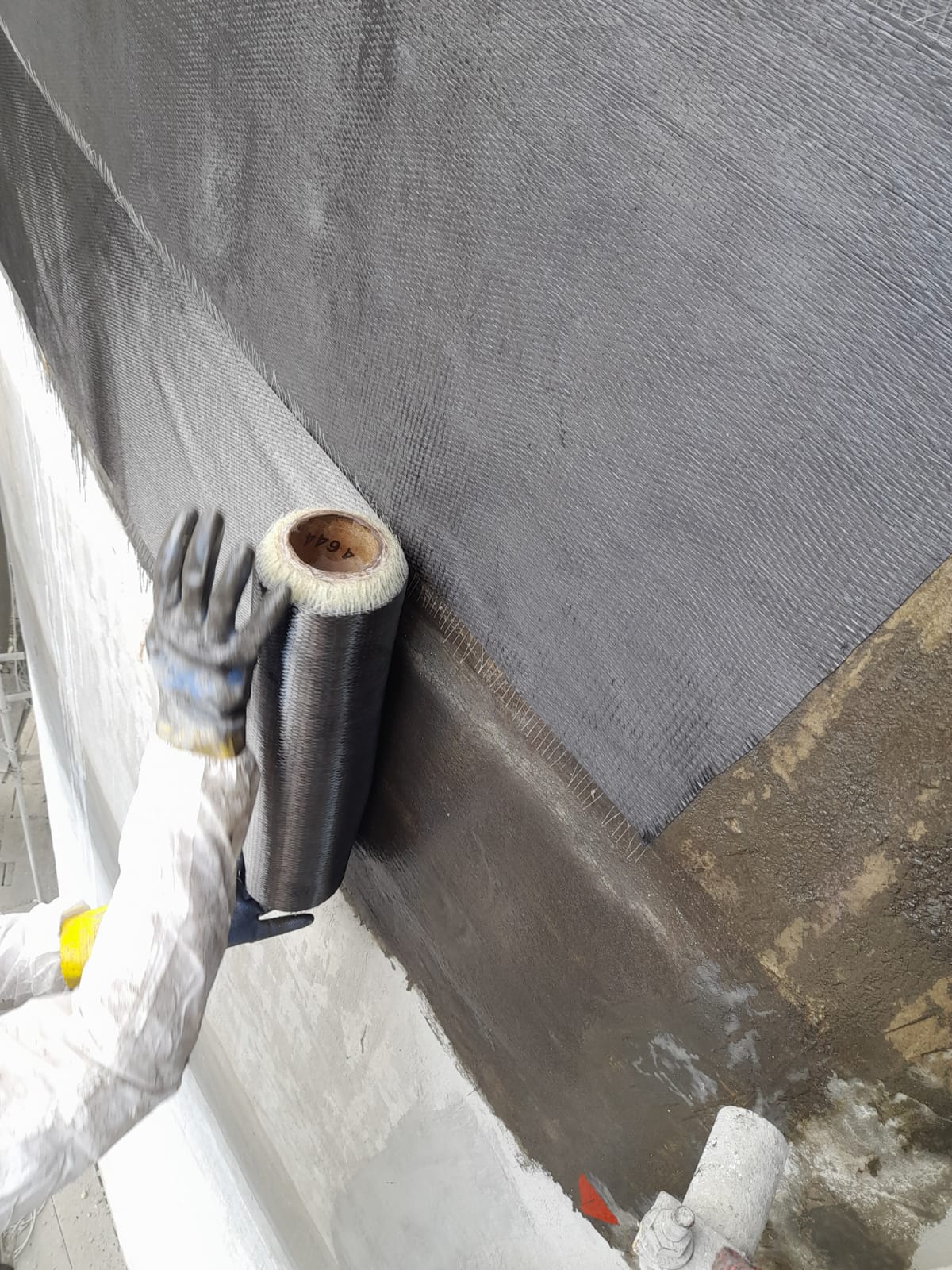 Detalhe da manta de fibra de carbono sendo posicionada na estrutura